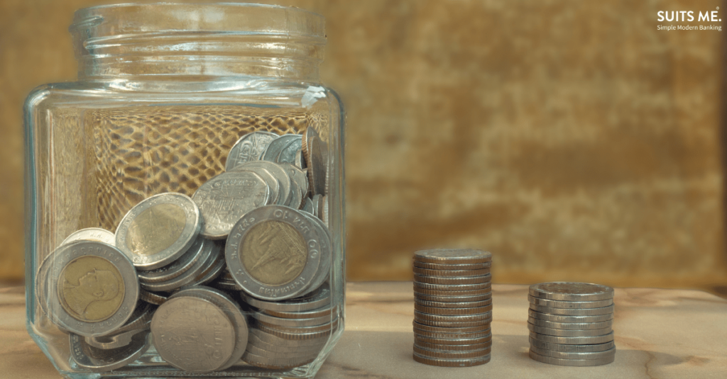 coins in a glass jar with two row of stacked coins of the same value with gold background. Representing only having access to cash based payments. Underbanked concept