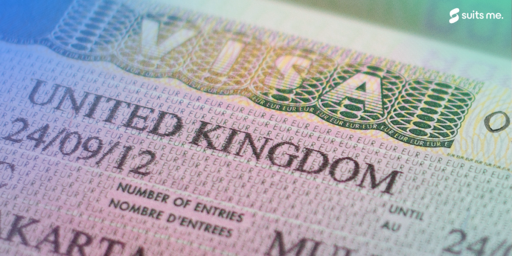 UK BRP (Biometrical Residence Permit) cards for Tier 2 work visa placed on top of UK VISA sticker in the passport. Close up photo.