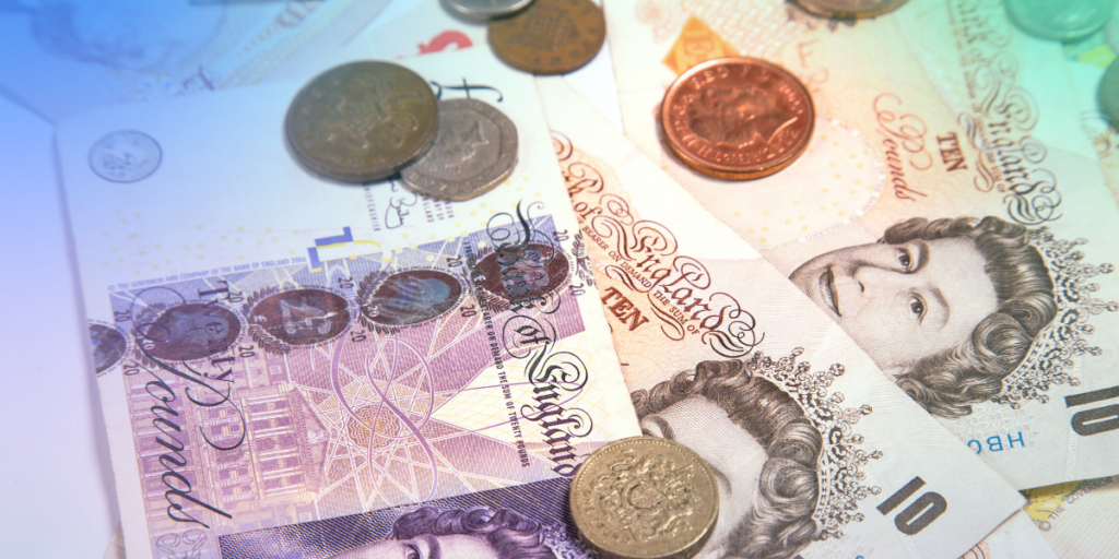 pound coins and notes spread out on a table