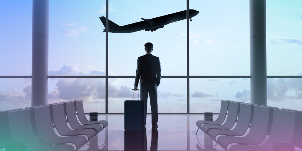 Man stood in airport looking out at the planes