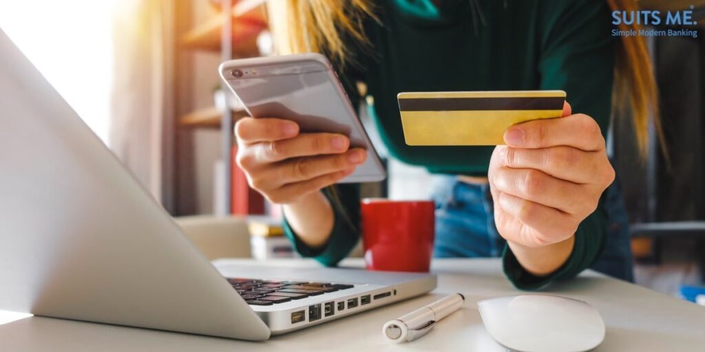 Woman's hands using laptop and holding credit card and smart phone with as digital banking concept