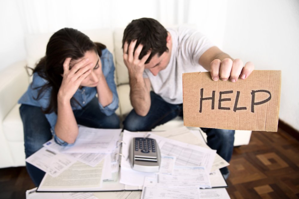 Young couple worried hold sign for help