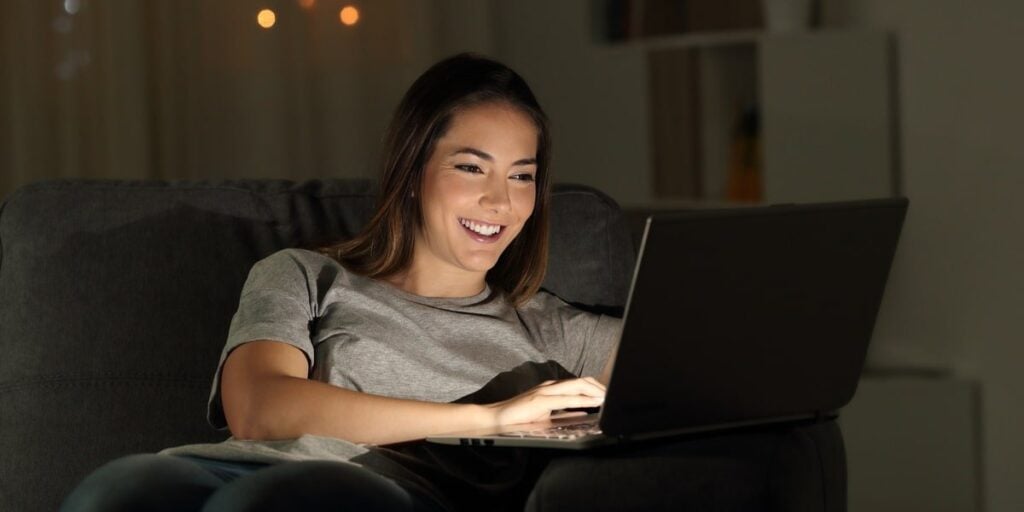 A girl happily online using her laptop