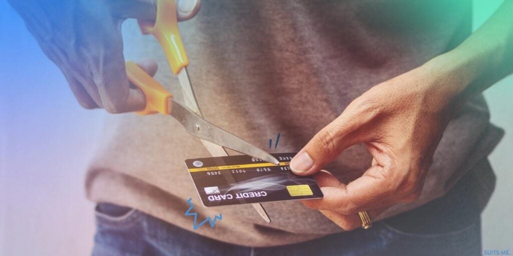 Man in Grey T-shirt Using Scissors to Cut Up his Credit Card to Cut Down on his Spending and Improve His Credit Score to Open a Bank Account