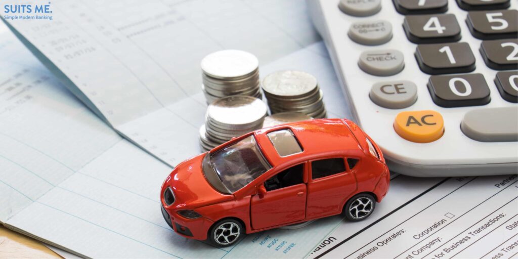 Car repayment concept. Toy car, money, calculator on top of financial documents.