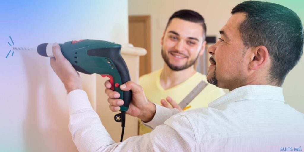 Dad teaching his son how to drill into a wall due to skills he has learned