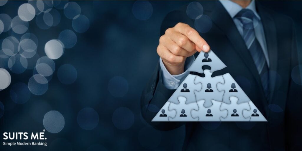 Recruiter holding pyramid scheme puzzle with CEO or person who makes the most money at the top