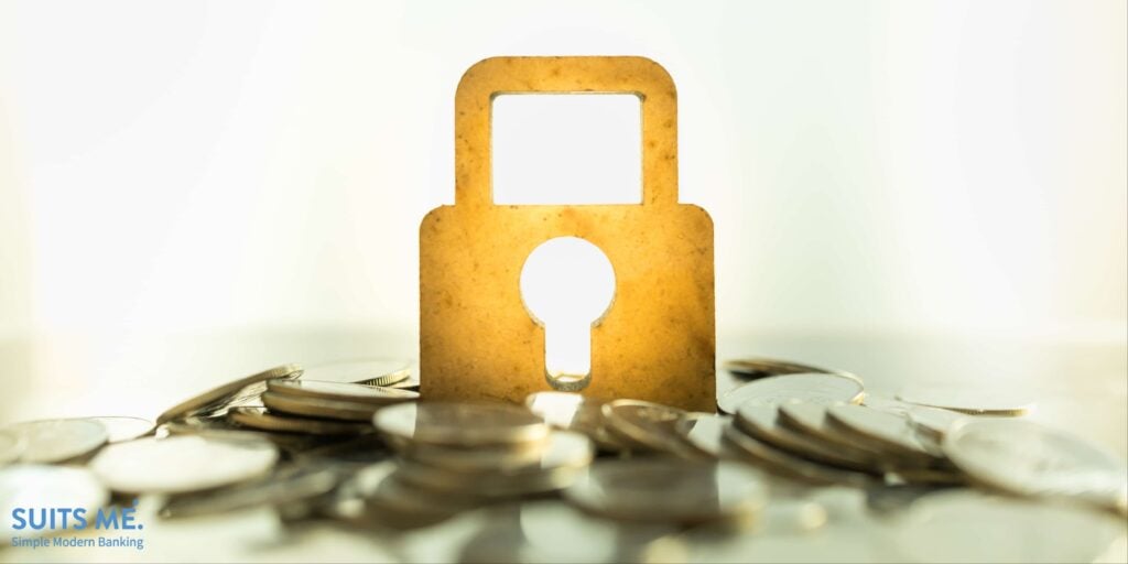 Money and Security Concept. Close up of wooden master key lock icon on pile of coins with copy space.