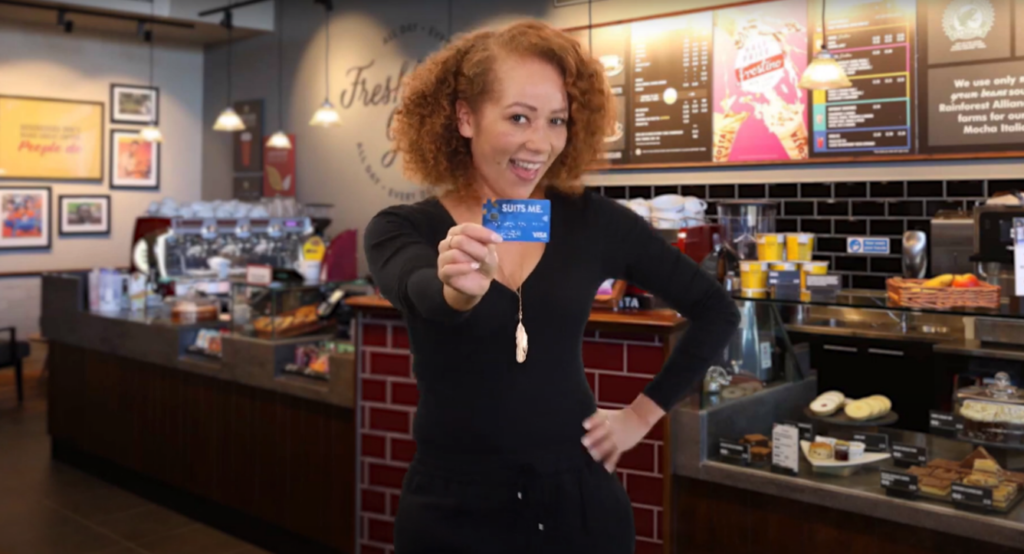 Woman holding Suits Me® card in TV campaign