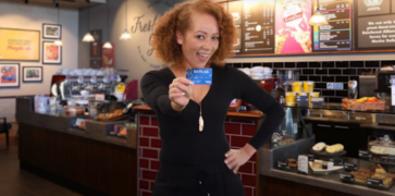 Woman holding Suits Me® card in TV campaign