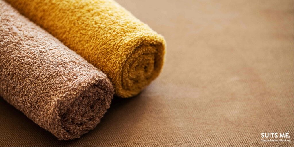 Brown and yellow rolled up rugs on beige carpet