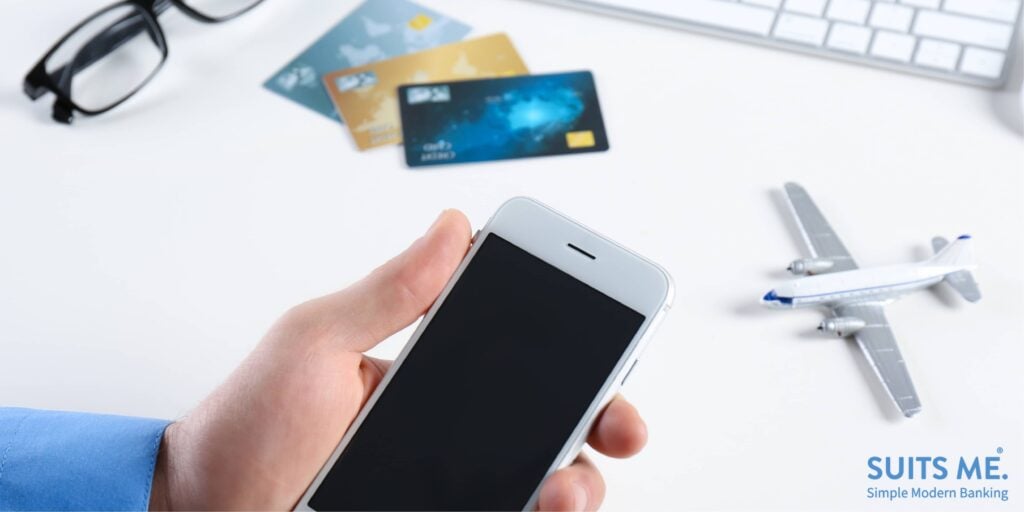 Man using mobile phone to research information about using a prepaid card abroad