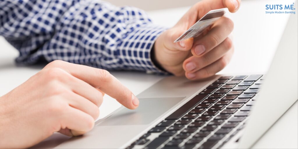 Man using a payroll card to pay for bills online using his laptop