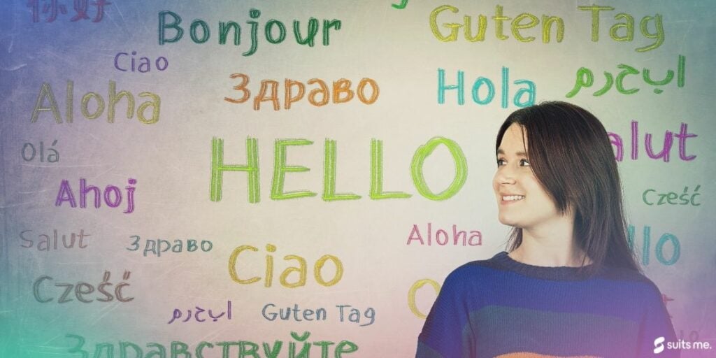 Woman looking happy against a wall of writing which reads "hello" in different languages