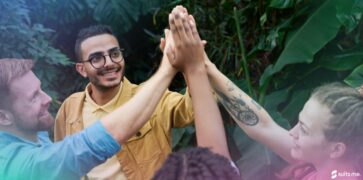 group of employees high-fiving and happy in their workplace