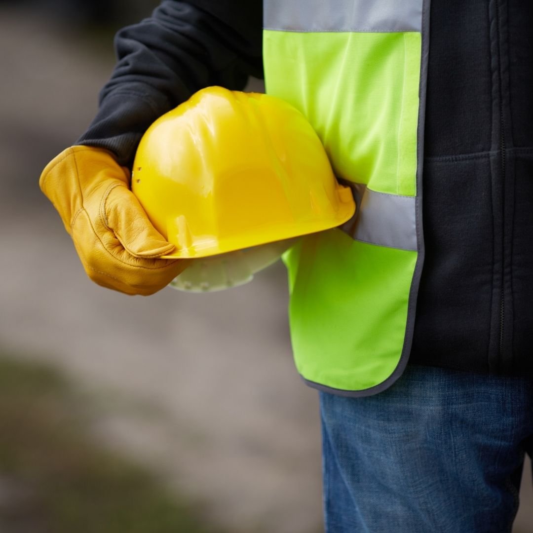 construction worker holding a yellow hard hat