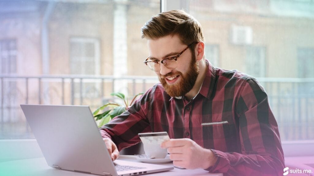 Man using a payroll card to pay for bills online using his laptop