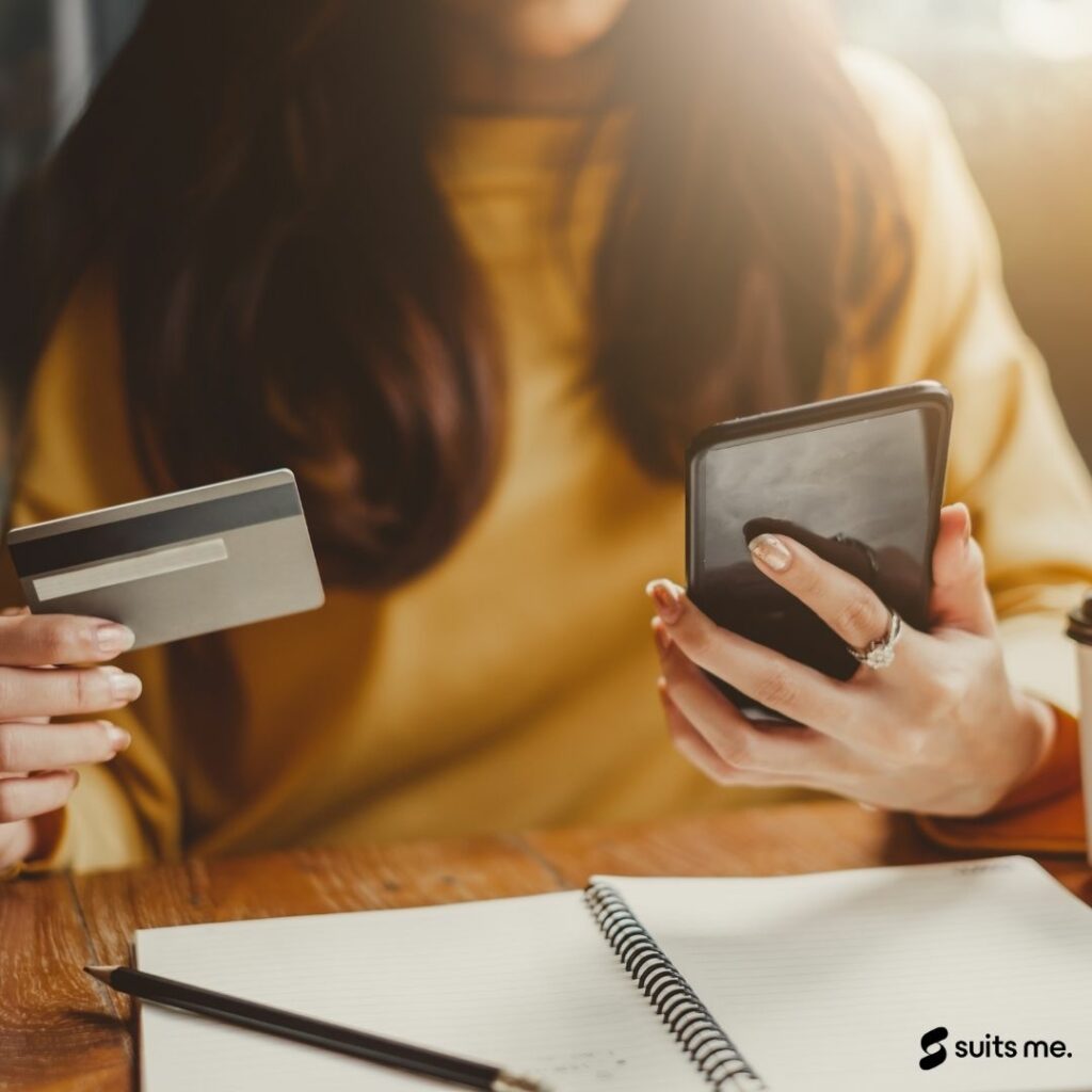 woman holding her card and looking through her online banking to see where her money is being spent