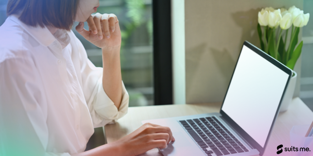 Woman sat infront of her laptop opening a bank account online on a desk with flowers and window in the background. Gradient sheen with Suits Me logo on top.